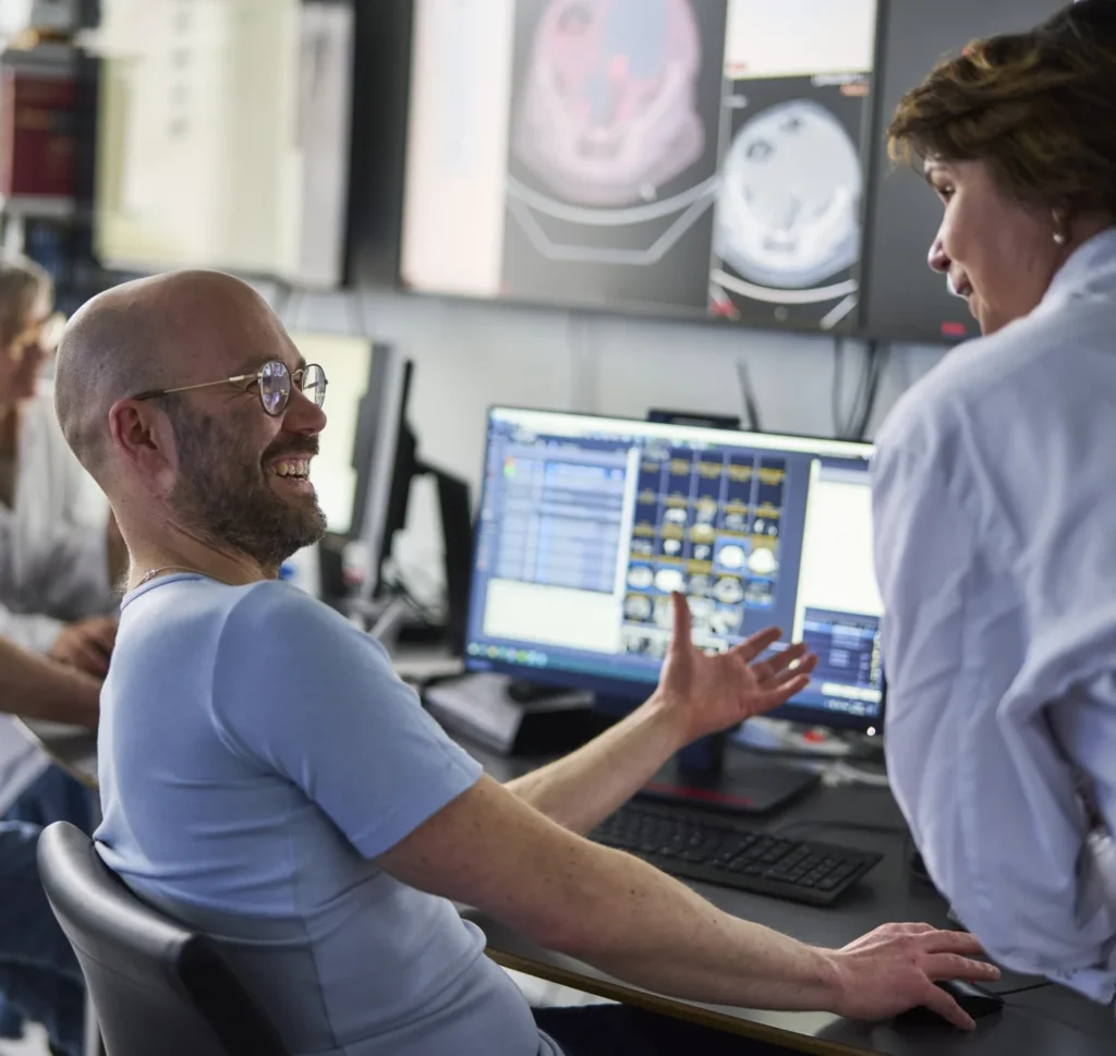 Photo of two researchers talking in front of a screen